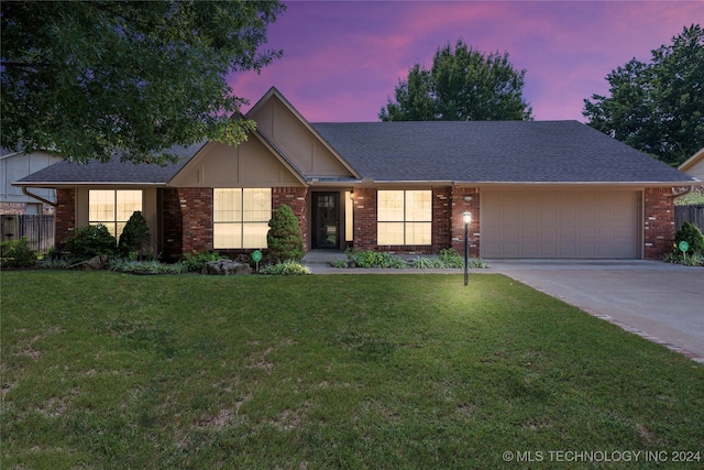 ranch-style house with a garage and a yard