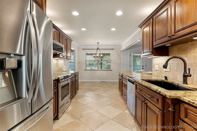 kitchen with pendant lighting, a notable chandelier, appliances with stainless steel finishes, sink, and light stone counters