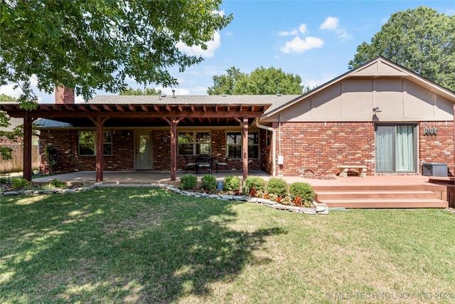 rear view of property featuring a pergola, a lawn, a patio, and a deck