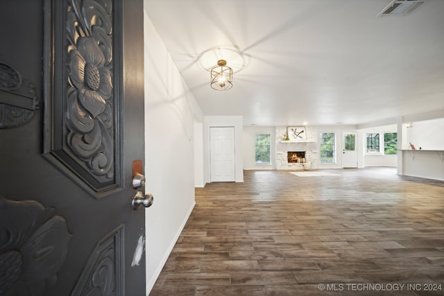 foyer entrance featuring hardwood / wood-style floors and a stone fireplace