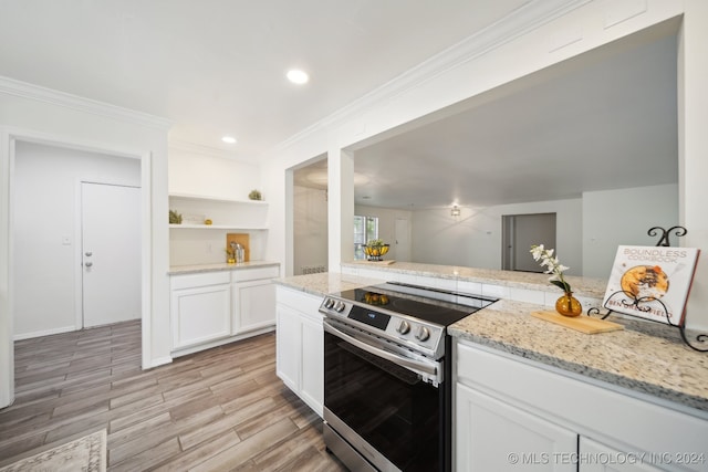 kitchen with light wood-type flooring, stainless steel range with electric cooktop, white cabinetry, crown molding, and light stone countertops