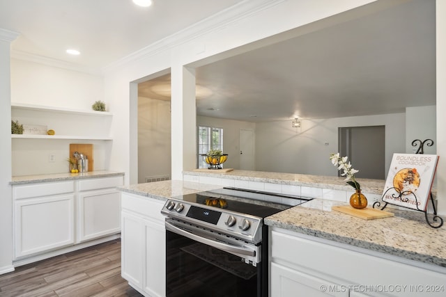 kitchen with ornamental molding, light hardwood / wood-style flooring, white cabinetry, electric range, and light stone countertops