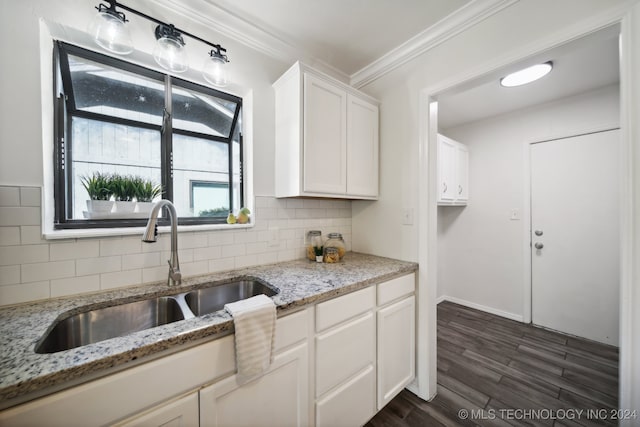 kitchen featuring white cabinetry, dark wood-type flooring, light stone counters, crown molding, and sink