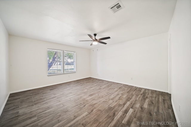 spare room featuring ceiling fan and dark wood-type flooring