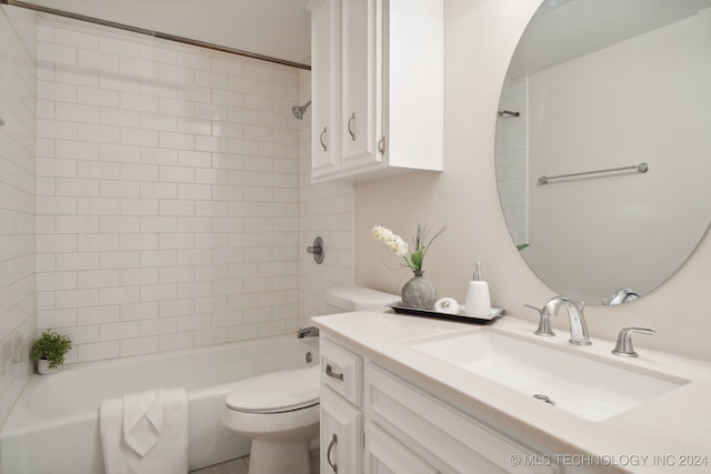 full bathroom with tiled shower / bath, vanity, and toilet