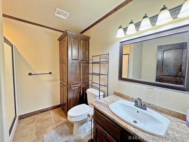 bathroom with a textured ceiling, vanity, tile patterned flooring, toilet, and ornamental molding