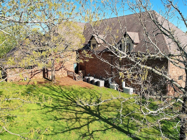 view of property exterior featuring a lawn and central air condition unit