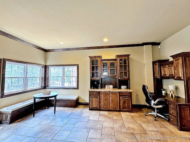 tiled office featuring ornamental molding and a textured ceiling