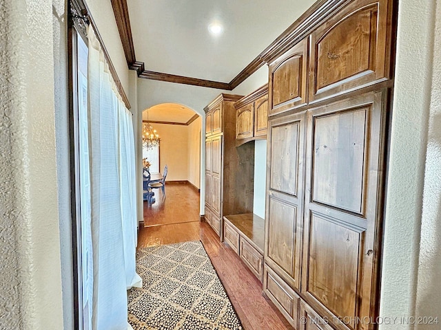 mudroom featuring light wood-type flooring, an inviting chandelier, and crown molding