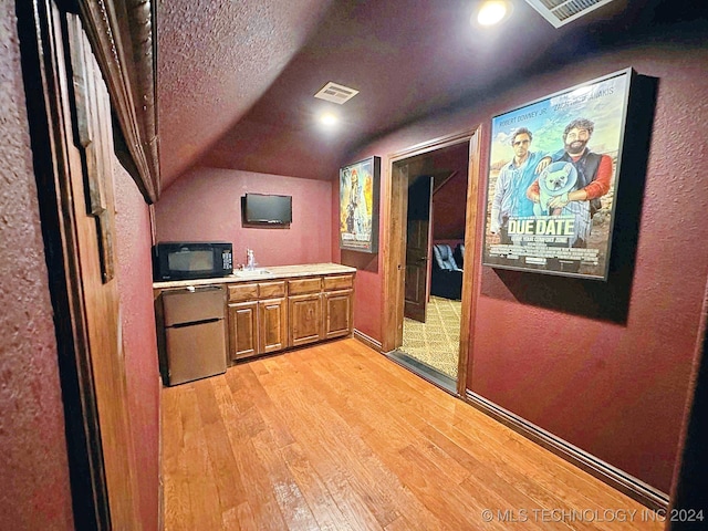 kitchen featuring a textured ceiling and light hardwood / wood-style floors