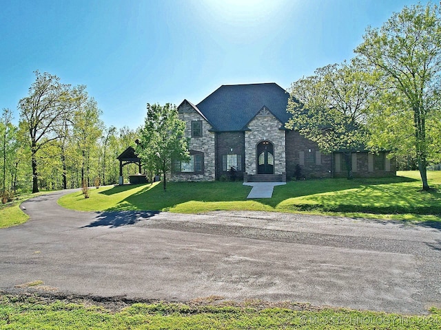 french country inspired facade featuring a front lawn