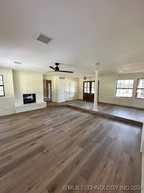 unfurnished living room featuring ceiling fan, dark hardwood / wood-style floors, and a brick fireplace