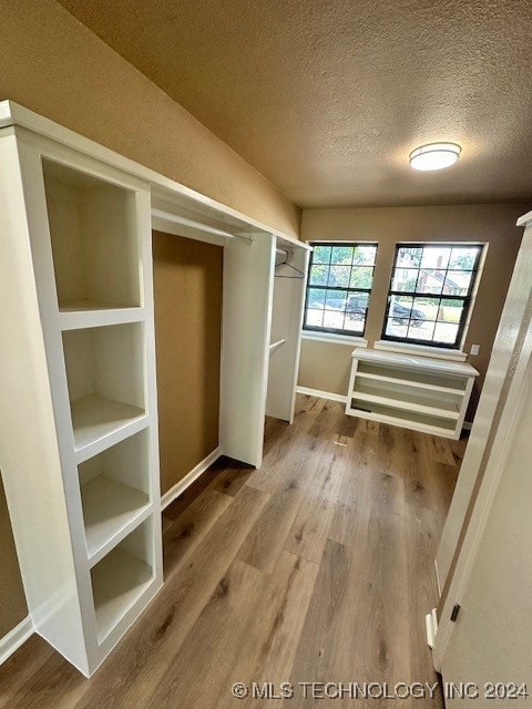 interior space featuring radiator, a textured ceiling, and hardwood / wood-style floors