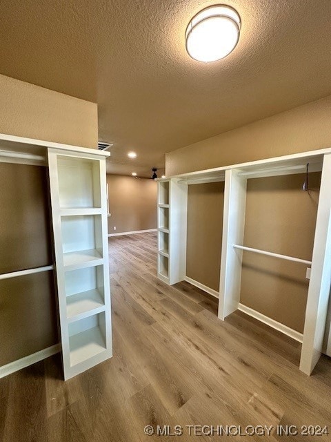 walk in closet with wood-type flooring