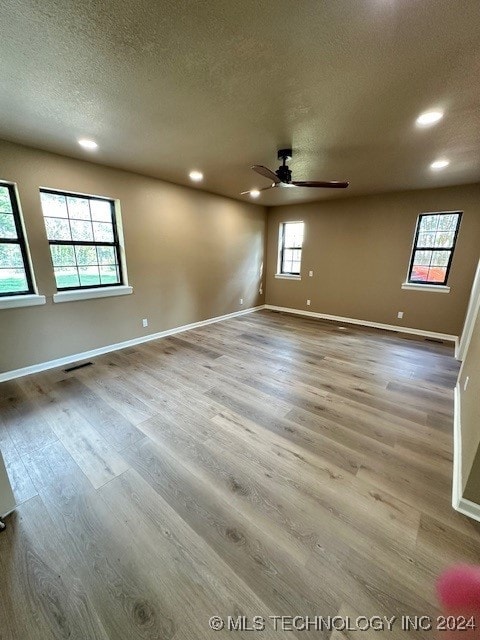 unfurnished room featuring a textured ceiling, hardwood / wood-style floors, and ceiling fan