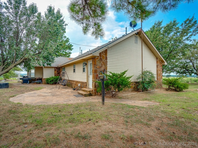 back of house with a yard and a patio