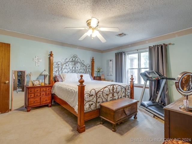 carpeted bedroom with ceiling fan and a textured ceiling