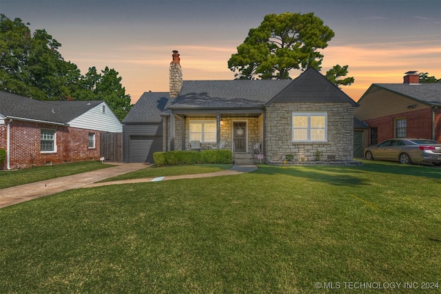 view of front facade featuring a front lawn, a garage, driveway, and a chimney