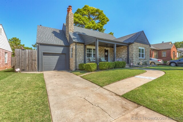 ranch-style house with covered porch, a front yard, and a garage