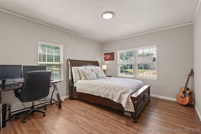 bedroom with crown molding and hardwood / wood-style flooring