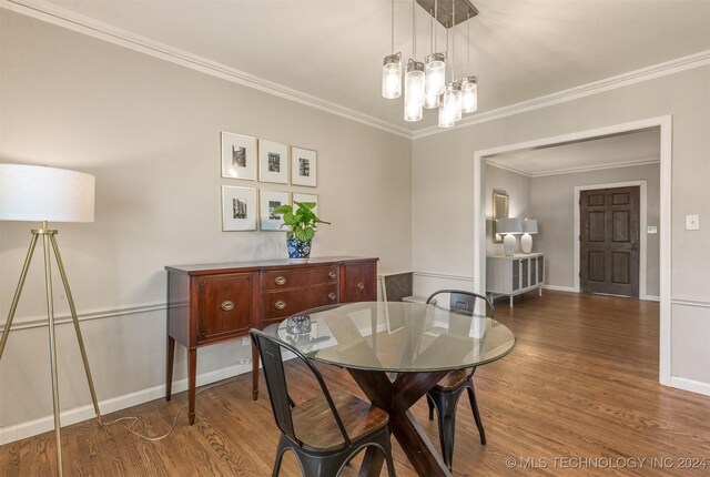 dining area with ornamental molding, dark hardwood / wood-style flooring, and a chandelier