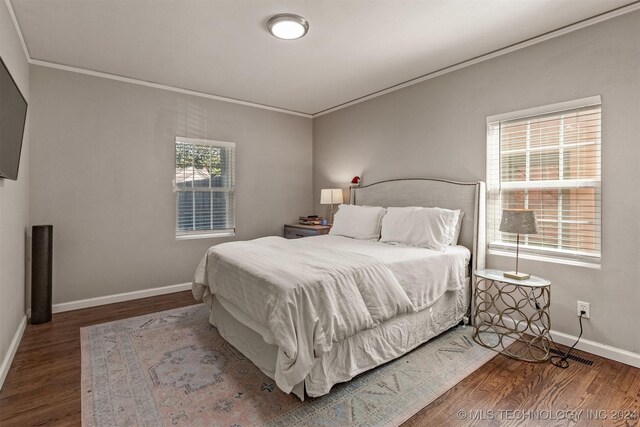 bedroom with crown molding and dark hardwood / wood-style floors