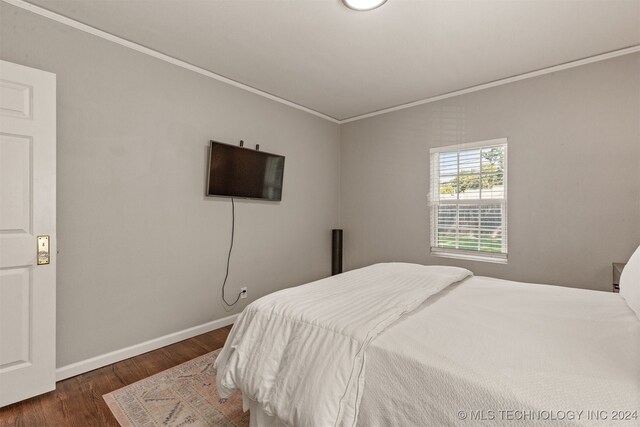 bedroom featuring dark wood-type flooring and ornamental molding