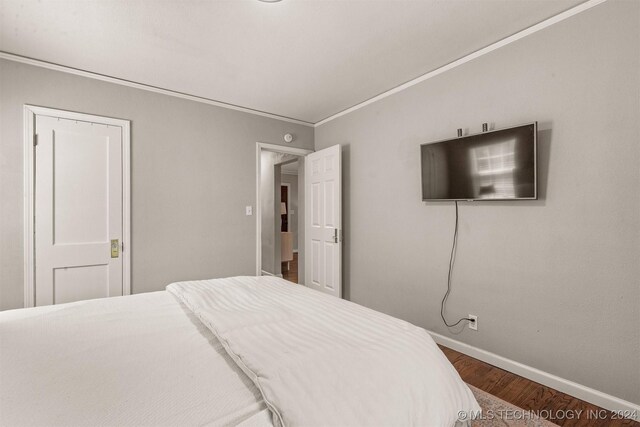 bedroom featuring dark wood-type flooring and ornamental molding