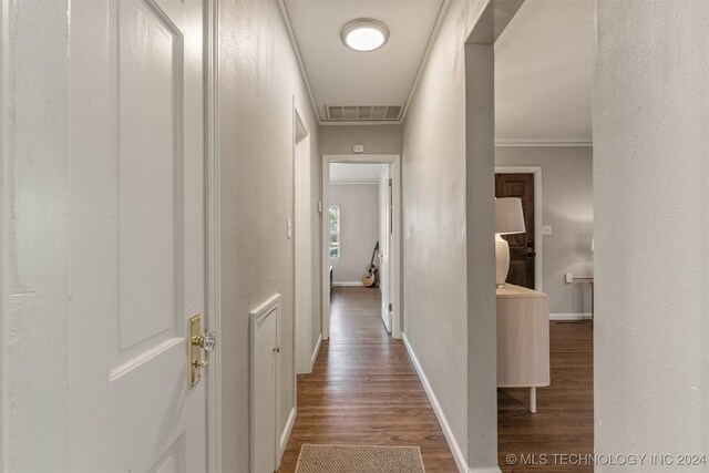 corridor with wood-type flooring and ornamental molding