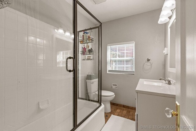 full bathroom featuring shower / bath combination with glass door, vanity, and toilet