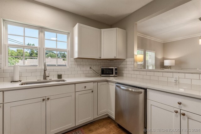 kitchen with backsplash, appliances with stainless steel finishes, dark hardwood / wood-style flooring, white cabinetry, and sink