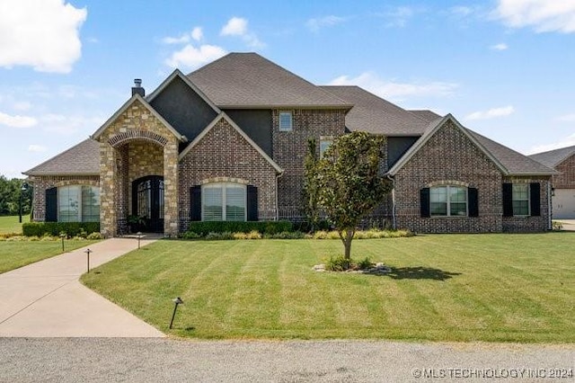 3526 Evans Ave, Mannford, OK 74044 - french country home featuring brick siding, a front lawn, and a chimney