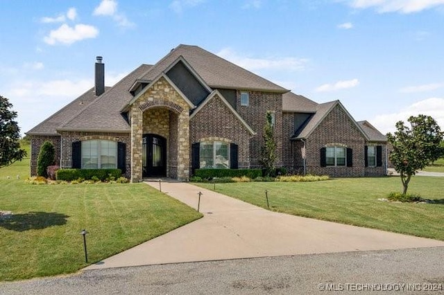 3526 Evans Ave, Mannford, OK 74044 - french provincial home featuring a chimney, a front lawn, and brick siding