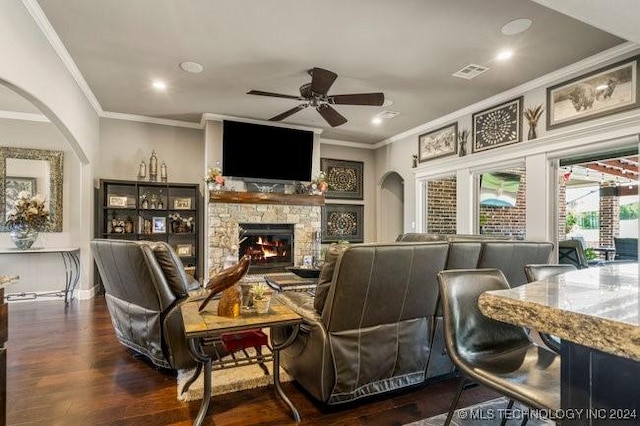 3526 Evans Ave, Mannford, OK 74044 - living area with arched walkways, crown molding, a ceiling fan, a fireplace, and wood finished floors