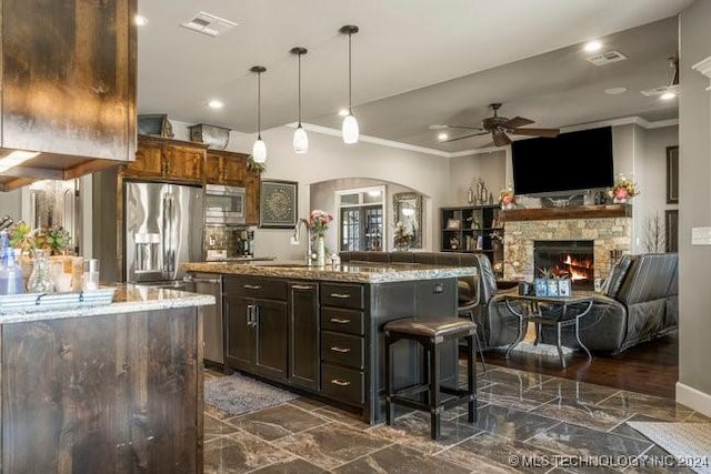3526 Evans Ave, Mannford, OK 74044 - kitchen with a ceiling fan, crown molding, appliances with stainless steel finishes, a fireplace, and a center island