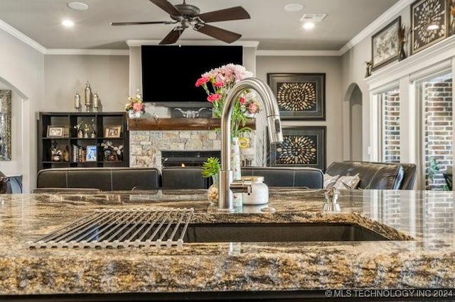 3526 Evans Ave, Mannford, OK 74044 - detailed view of a fireplace, arched walkways, ceiling fan, crown molding, and recessed lighting