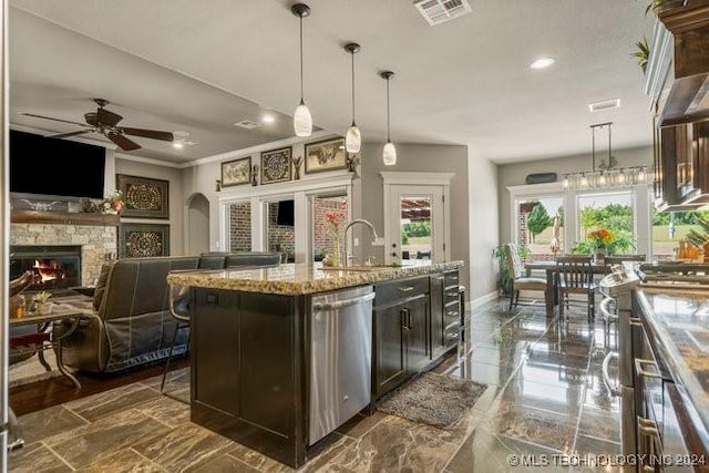 3526 Evans Ave, Mannford, OK 74044 - kitchen featuring stainless steel dishwasher, a sink, a ceiling fan, a stone fireplace, and baseboards