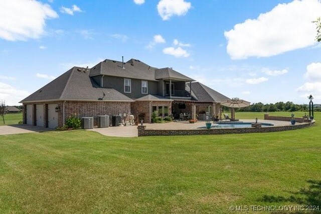 3526 Evans Ave, Mannford, OK 74044 - rear view of house with a balcony, central AC, a patio area, and a lawn