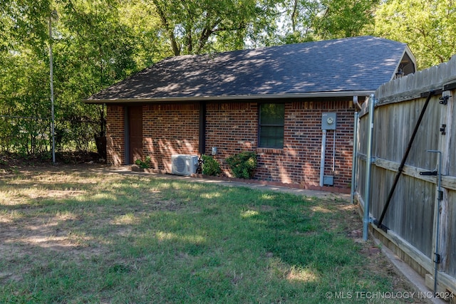 view of outbuilding with a lawn and central air condition unit