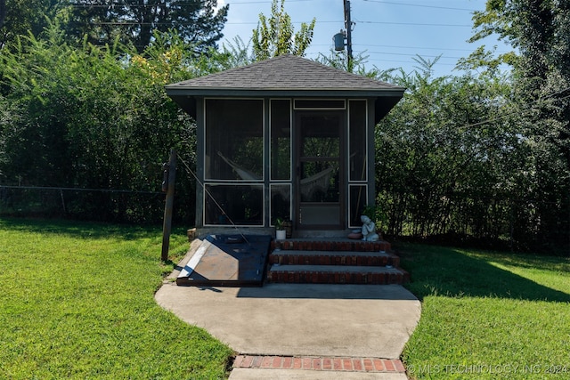 exterior space featuring a sunroom and a lawn