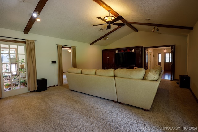 unfurnished living room featuring a healthy amount of sunlight, carpet, lofted ceiling with beams, and ceiling fan