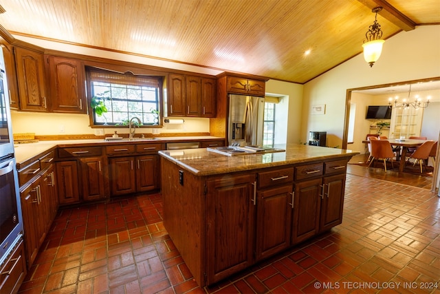 kitchen with pendant lighting, stainless steel appliances, a center island, vaulted ceiling with beams, and sink