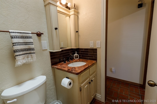 bathroom with vanity, backsplash, and toilet