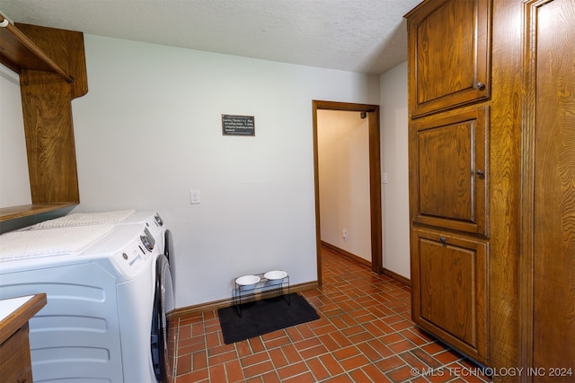 laundry room with a textured ceiling, washer and dryer, and cabinets