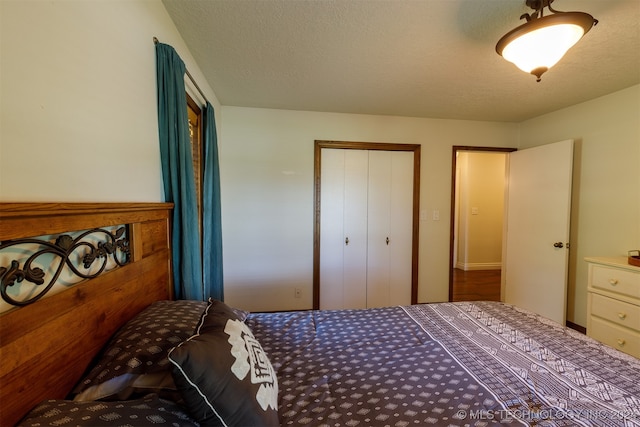 bedroom with a textured ceiling and a closet