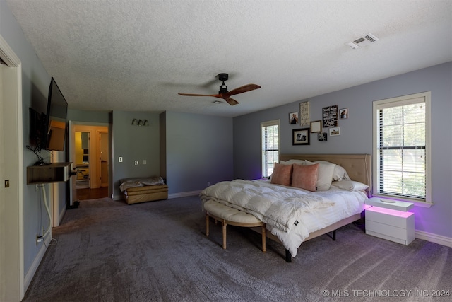 carpeted bedroom with ceiling fan and a textured ceiling