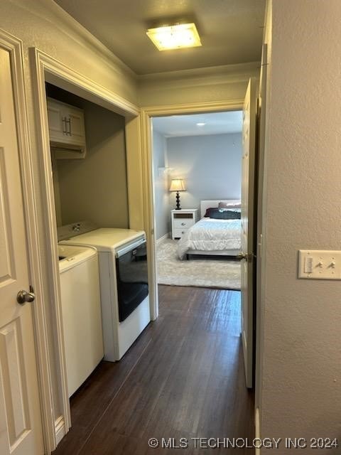 clothes washing area with dark hardwood / wood-style floors and washer and clothes dryer