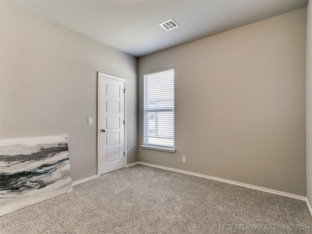 unfurnished room with baseboards, visible vents, and carpet flooring