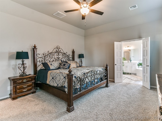 carpeted bedroom with ensuite bath and ceiling fan