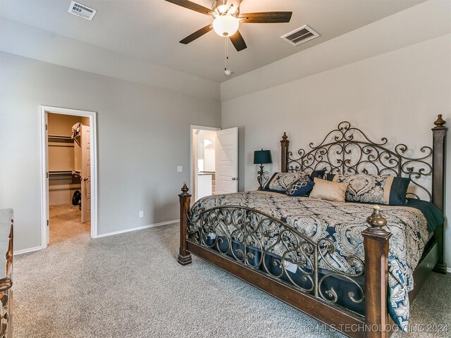 carpeted bedroom featuring a walk in closet, visible vents, ceiling fan, and baseboards